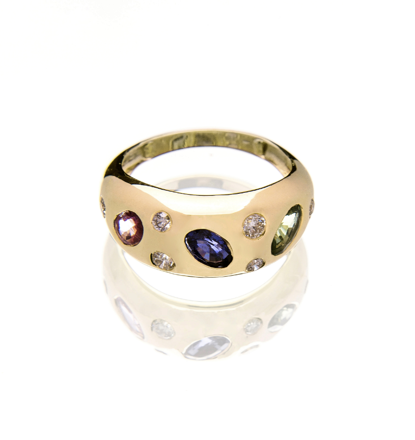 Gold ring with embedded gemstones on a white background